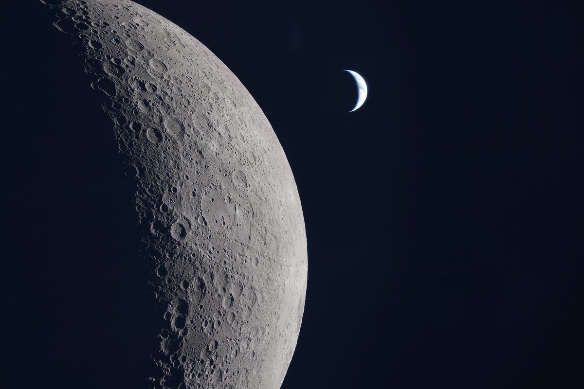 The Moon’s cratered limb with a thin crescent Earth beyond, photographed from deep space